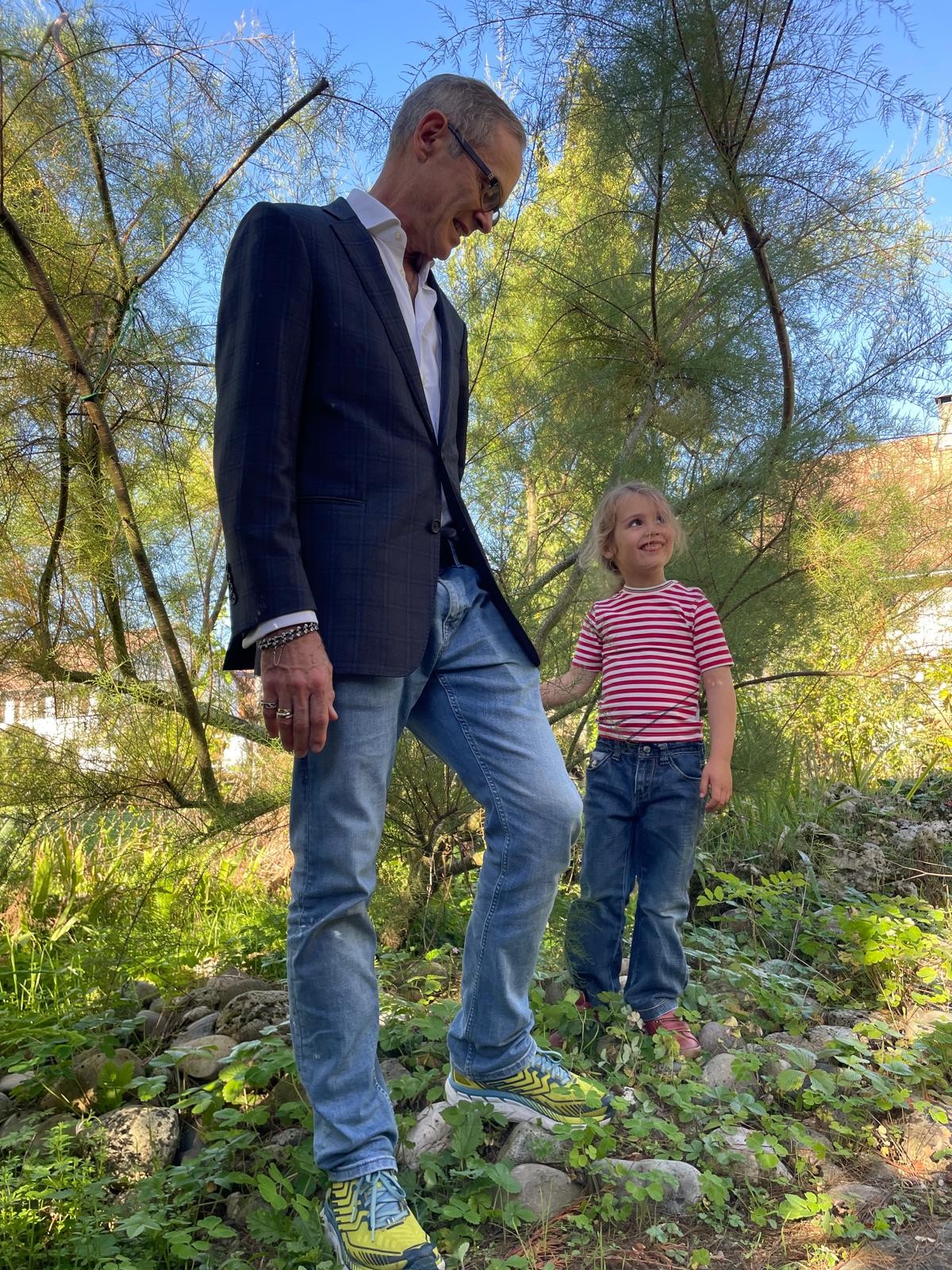 Jeremy walking through a garden with a small child